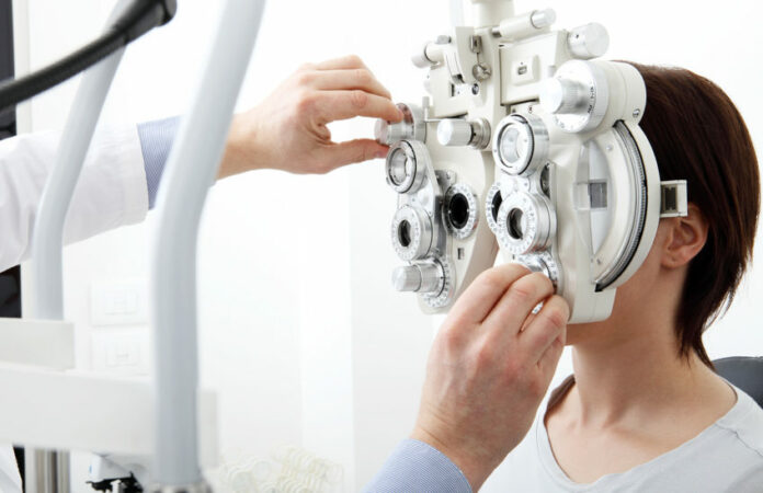 woman doing eyesight measurement with optical phoropter