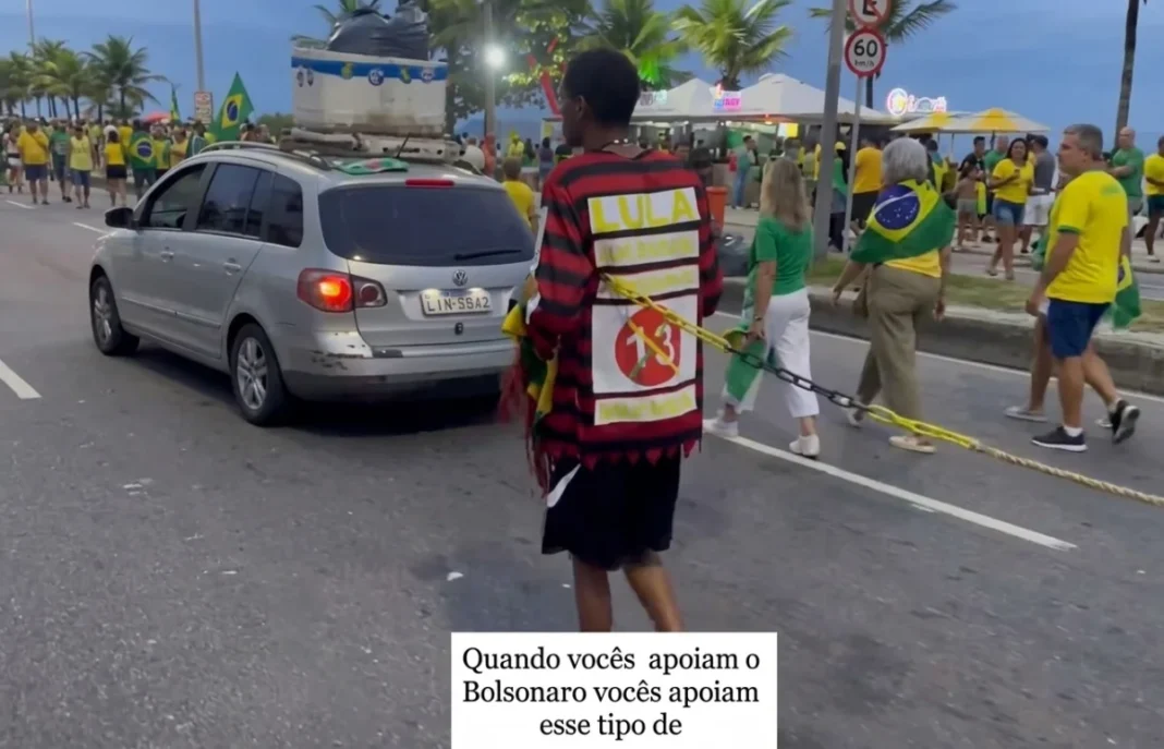 Chocante: em ato de Flávio, homem negro é preso por corrente
